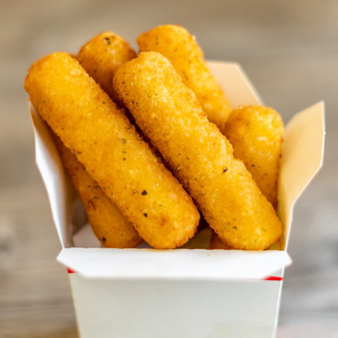 Golden mozzarella sticks in a takeout tray